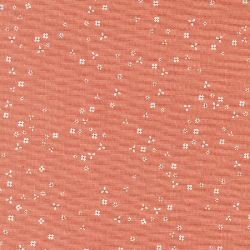Coral orange fabric with scattered, tiny white flower blossoms.
