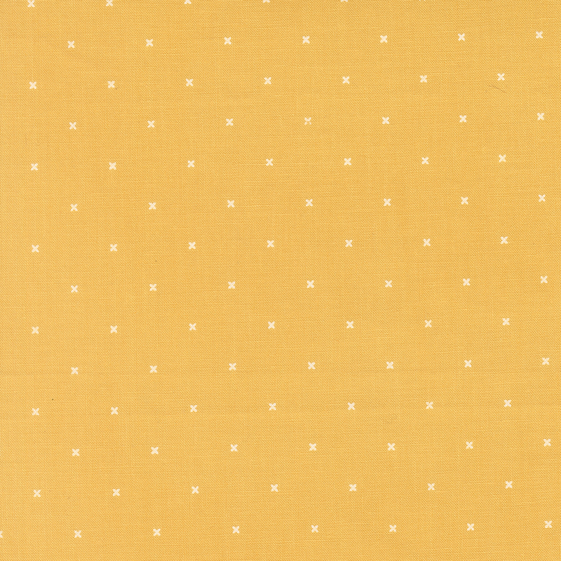 Bright yellow fabric with small x's that resemble cross stitching.