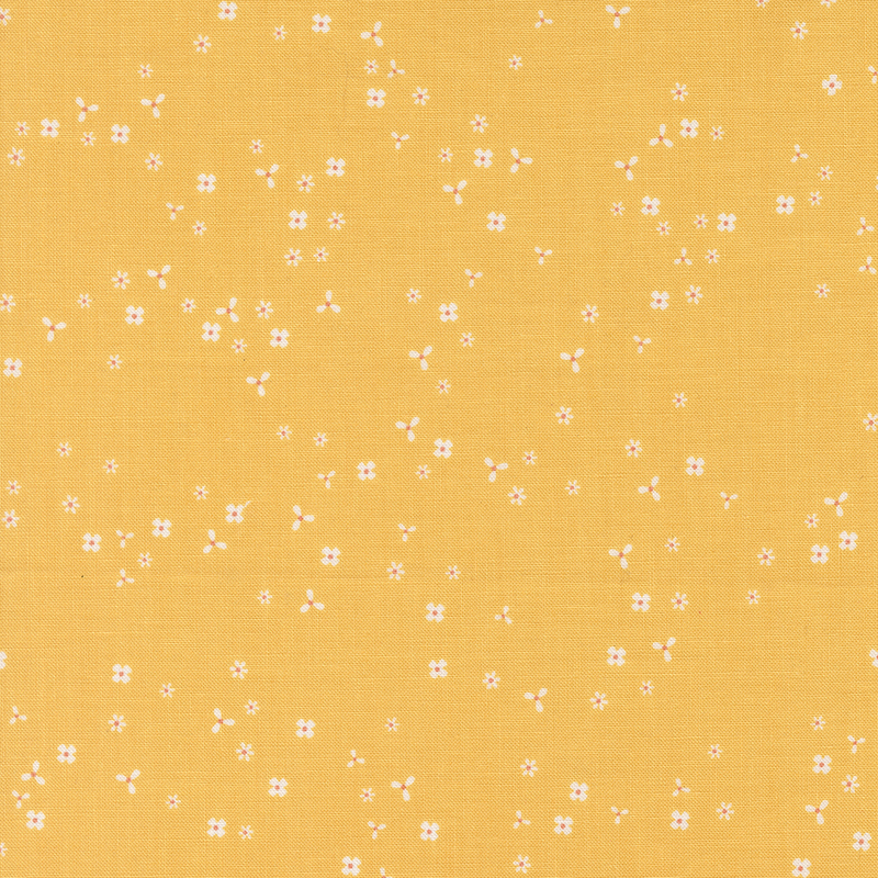 Golden yellow fabric with scattered, tiny white flower blossoms.