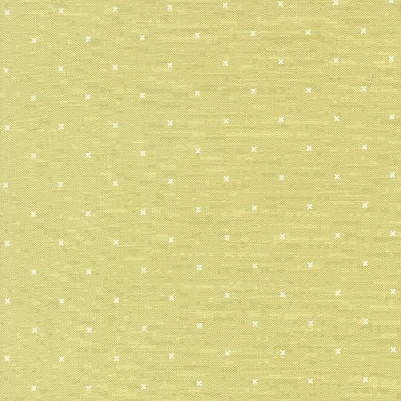 Light lime green fabric with small x's that resemble cross stitching.