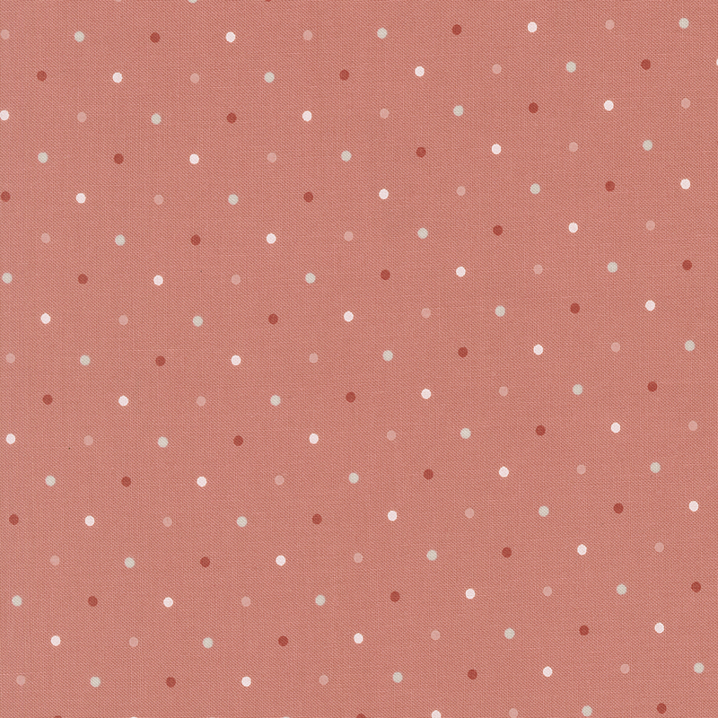 Coral pink fabric with a white, pink, and red polka dot pattern.