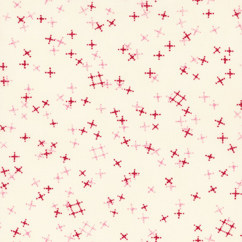 Light cream fabric with tossed light pink and red crosses and pound signs.