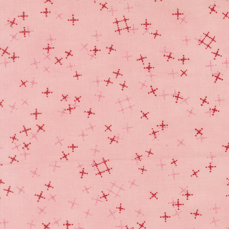 Blush pink fabric with tossed red and tonal crosses and pound signs.
