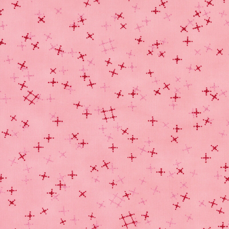 Blush pink fabric with tossed red and tonal crosses and pound signs.