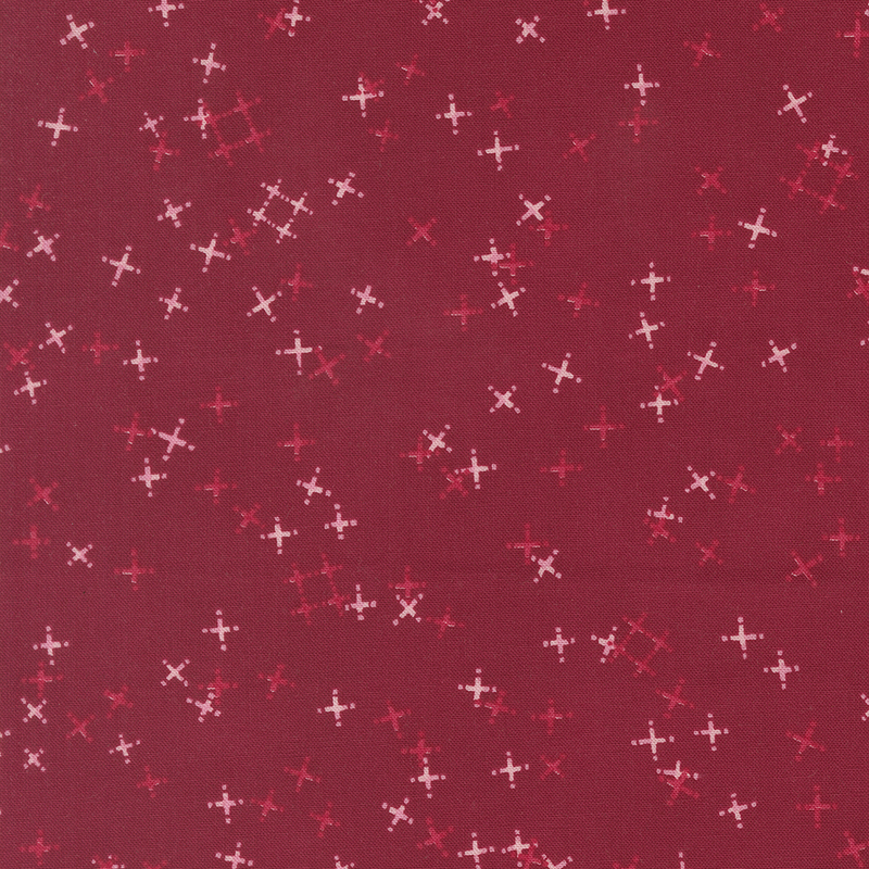 Cranberry red fabric with tossed light pink and tonal crosses and pound signs.