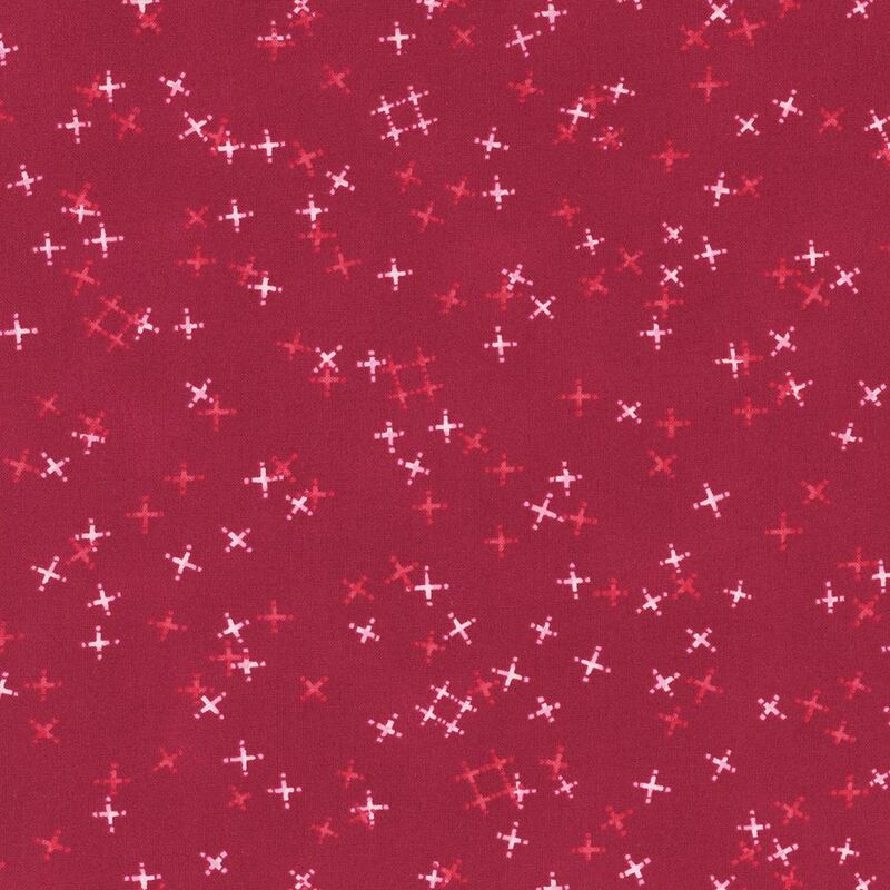 Cranberry red fabric with tossed light pink and tonal crosses and pound signs.