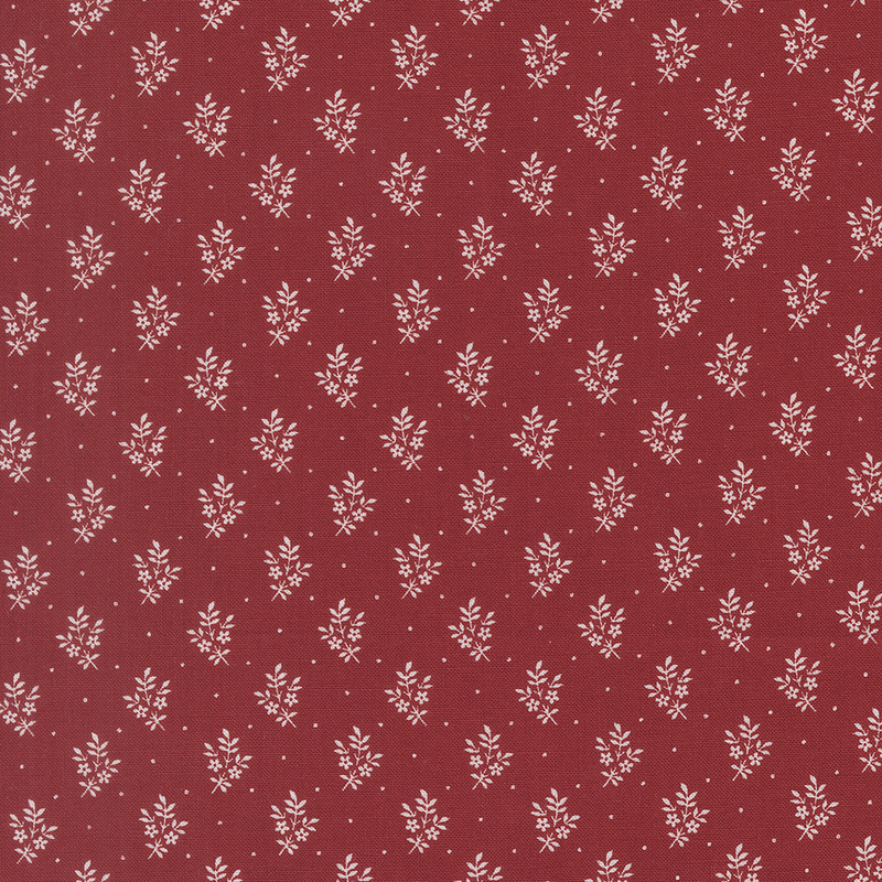 Red fabric with a repeating white floral pattern on a dark red background.