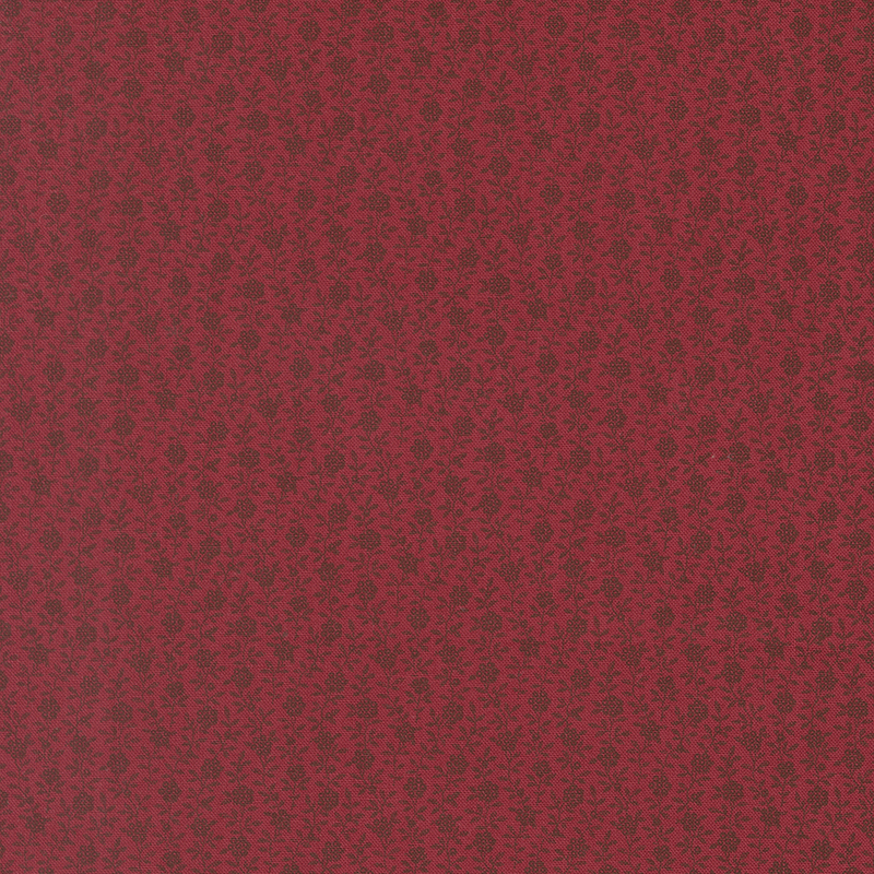 Textured red fabric with a subtle floral pattern.