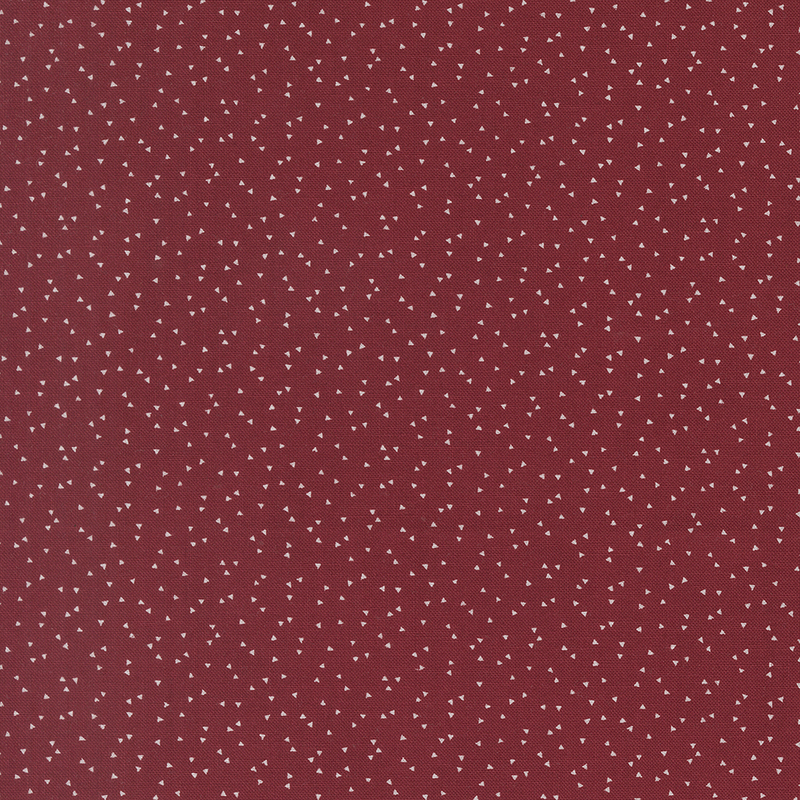 A maroon background featuring a scattered pattern of small white dots.