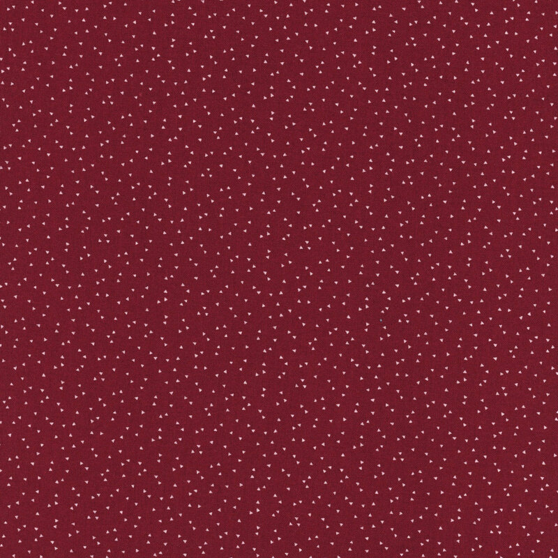 A maroon background featuring a scattered pattern of small white dots.