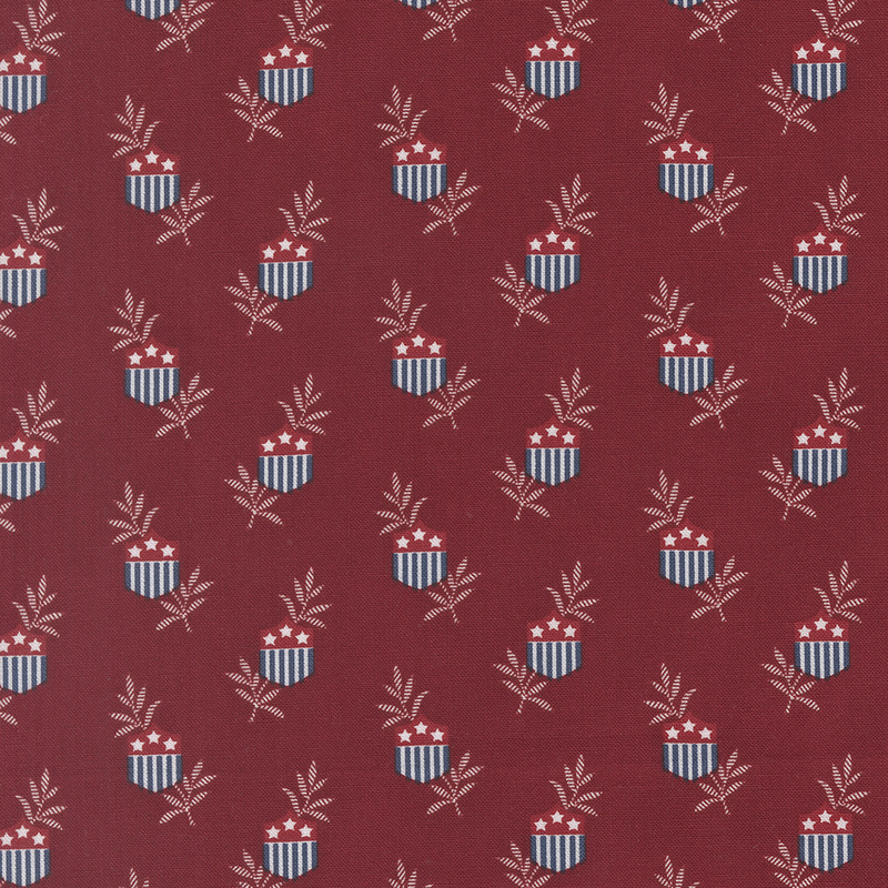 Red fabric featuring a repeating pattern of shield emblems with stars and leaves.