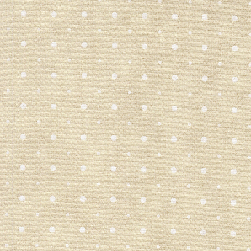 A cream fabric with small and medium sized white polka dots.