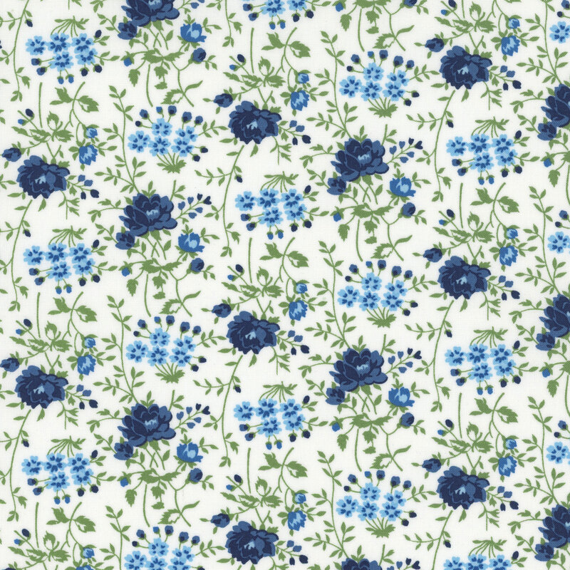 White fabric with navy and light blue florals with sprawling green stems.