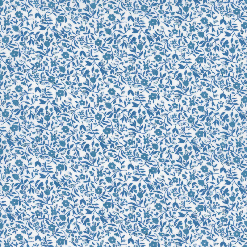 White fabric with a packed design of blue florals and sprawling leaves.