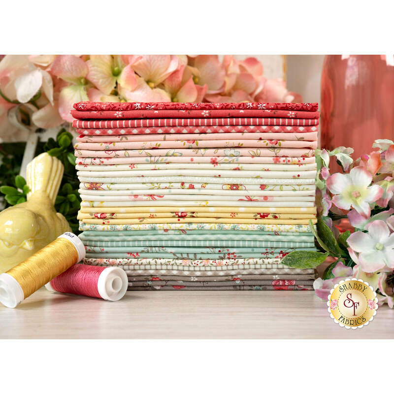 A stack of the fabrics featured in the Lyda Rose F8 set, with flowers and a pitcher and a bird and thread.