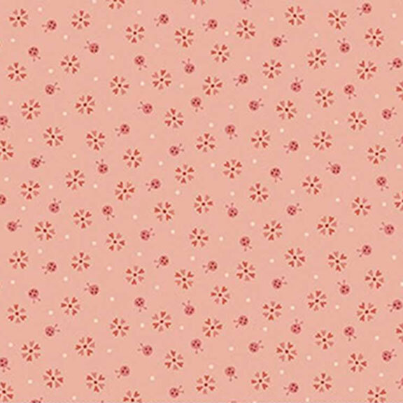 Tonal salmon fabric with small ladybugs, flowers, and pinprick dots.