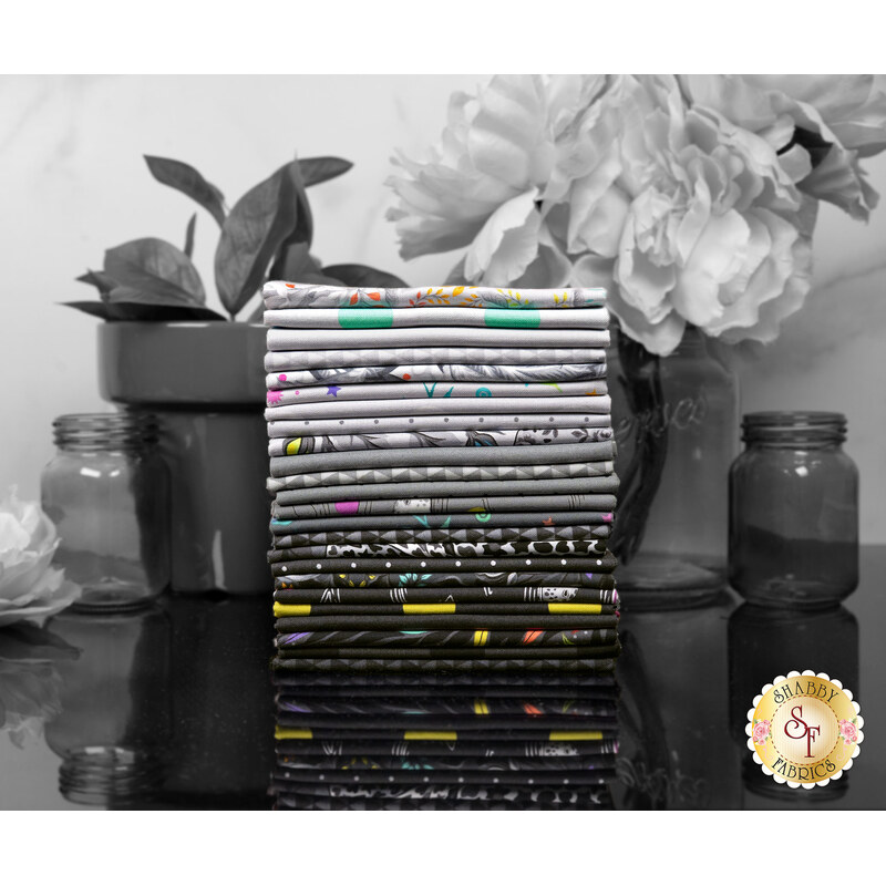 A stack of the fabrics included in the Graywork collection, with flowers and vases and jars.