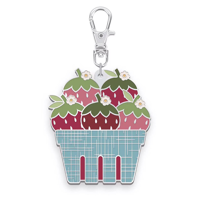 Enamel pin with a lobster clasp featuring the design of a blue basket stacked with strawberries, isolated on a white background.