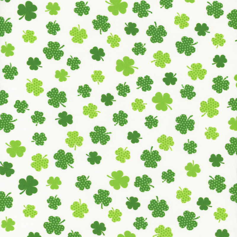 A white background filled with various green clovers in different shades and patterns.