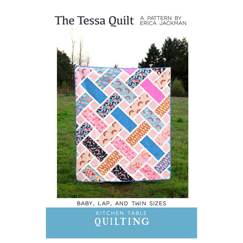 The front of the Tessa Quilt pattern showing the finished quilt hung up by someone standing in a grassy field.