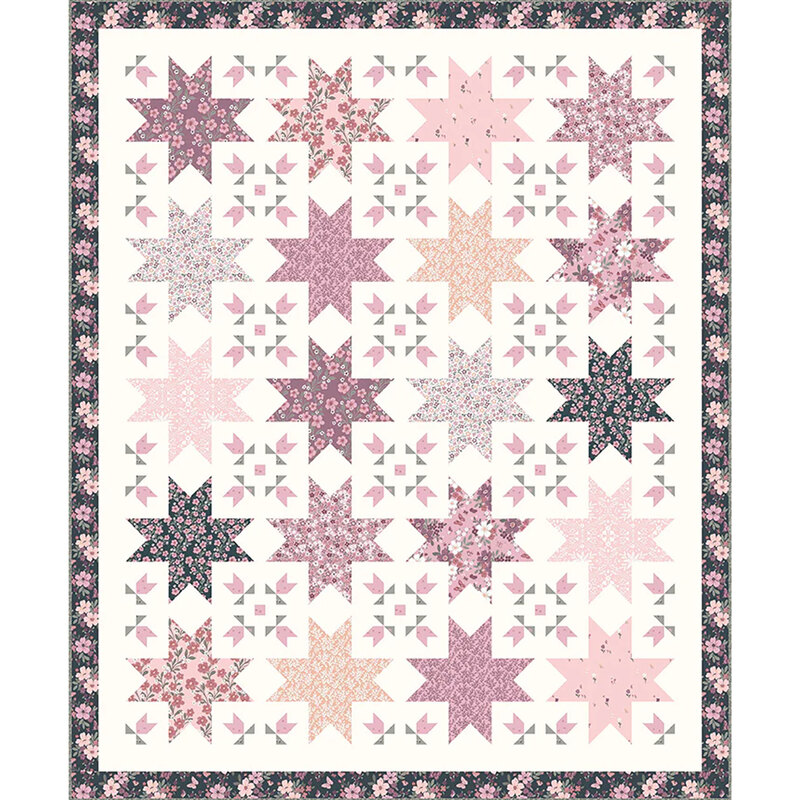 A quilt featuring a pattern of pink and purple stars on a light background with floral borders.