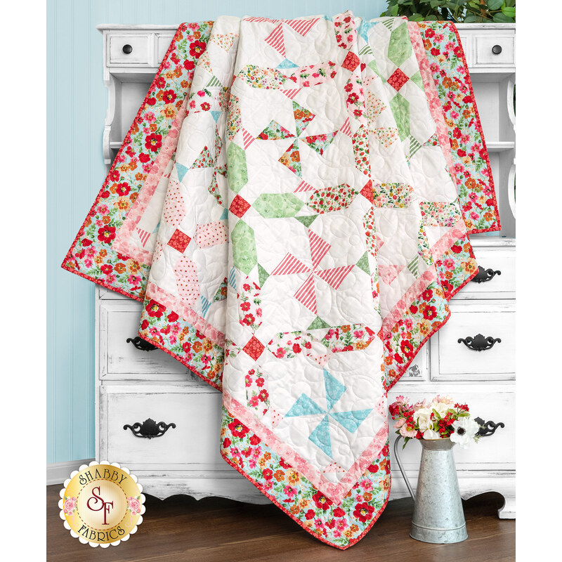 A shot of the quilt artfully draped over a white hutch, demonstrating movement and form.