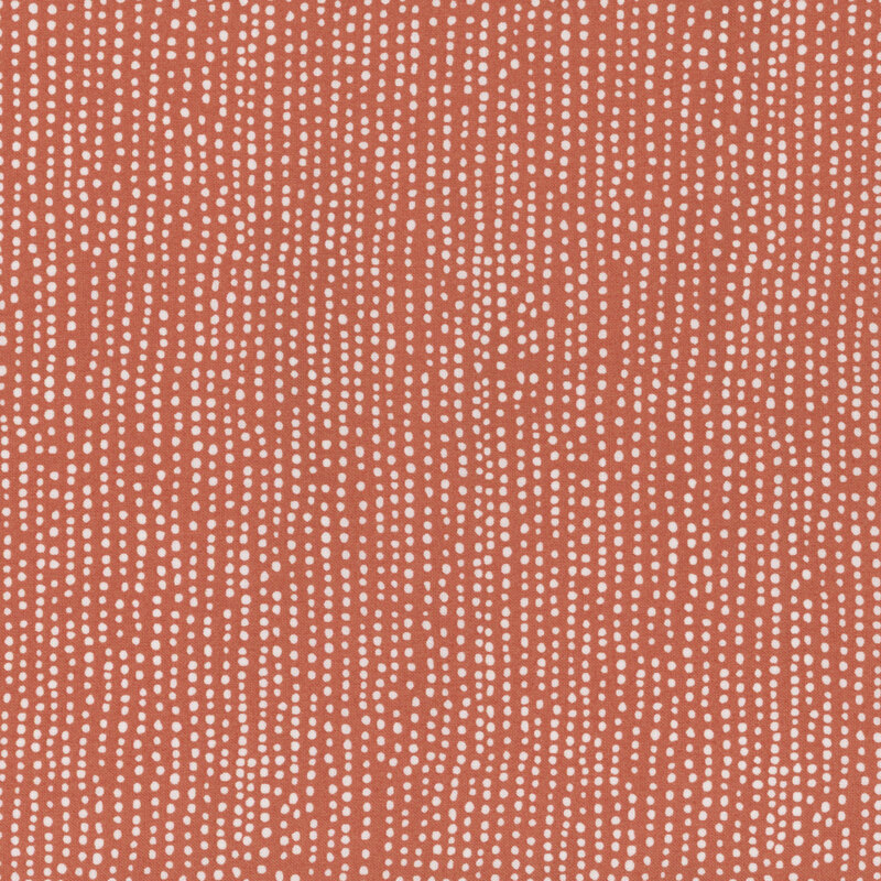 Burnt orange fabric with vertical rows of wobbly white dots.