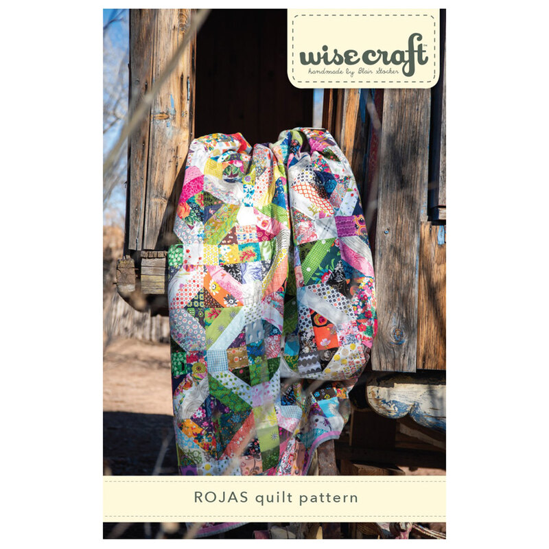 The front of the Rojas Quilt Pattern, showing the finished quilt draped over a rustic wooden structure.