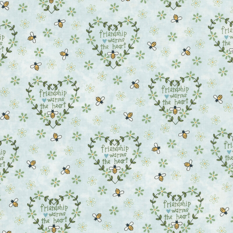 Pale blue fabric with a repeating fabric pattern of hearts, flowers, and bees, featuring the text "Friendship warms the heart."