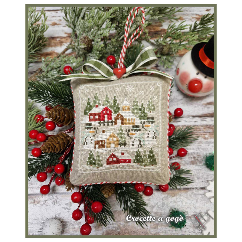 The completed project, a small snowy village, staged with coordinating winter and holiday decor.