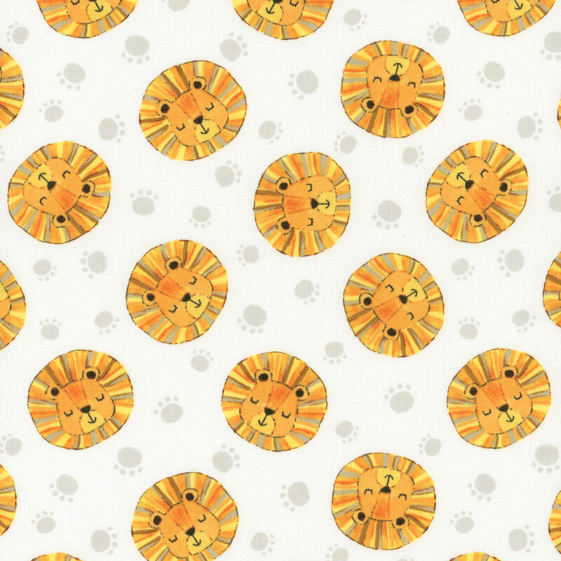 Lion heads in yellow, orange, and gold tossed with silver paw prints on white fabric