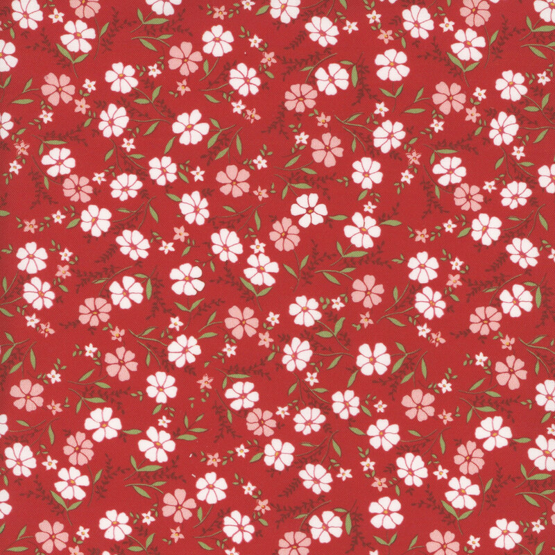 Red fabric with a calico pattern of tossed with white and pink flowers with green leaves.