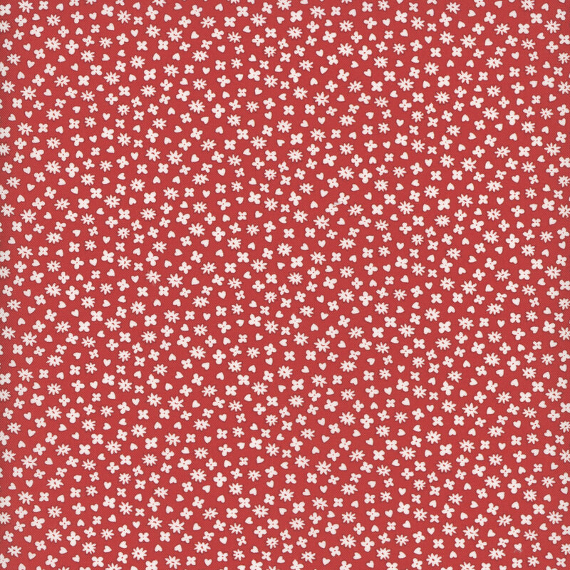 Vibrant red fabric featuring a small pattern of evenly spaced white flowers and red hearts.