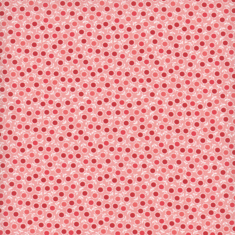 Red, salmon, and coral circles outlined with tiny white petals and stems on pink fabric.