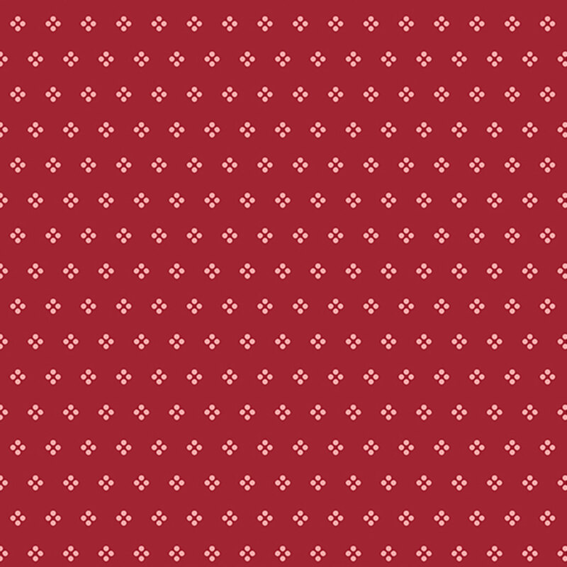 Calico dark red fabric with white dots arranged in groups.