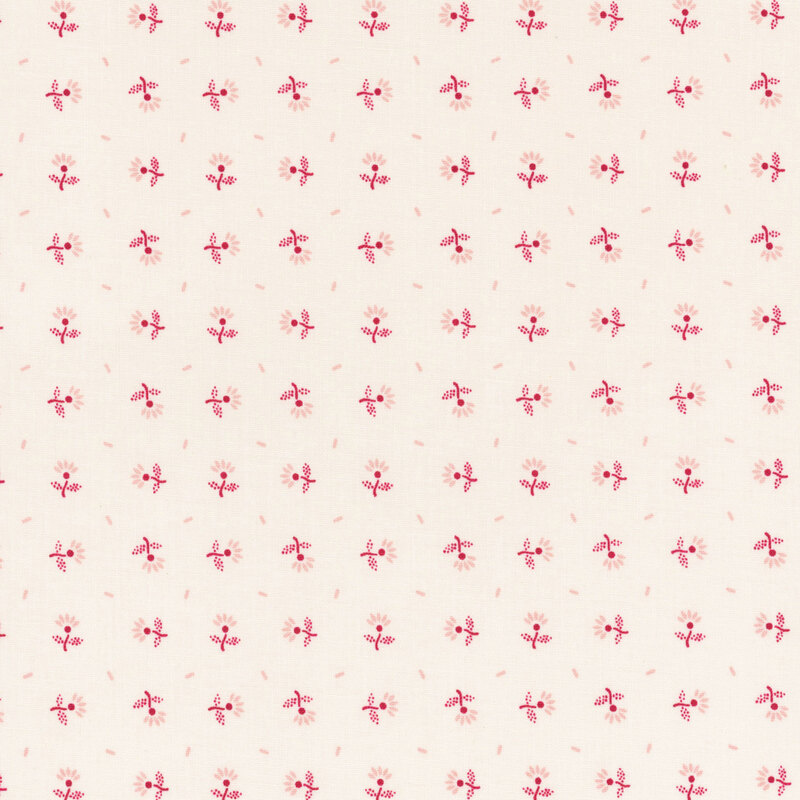 Red flowers and flower petals tossed on ivory fabric.