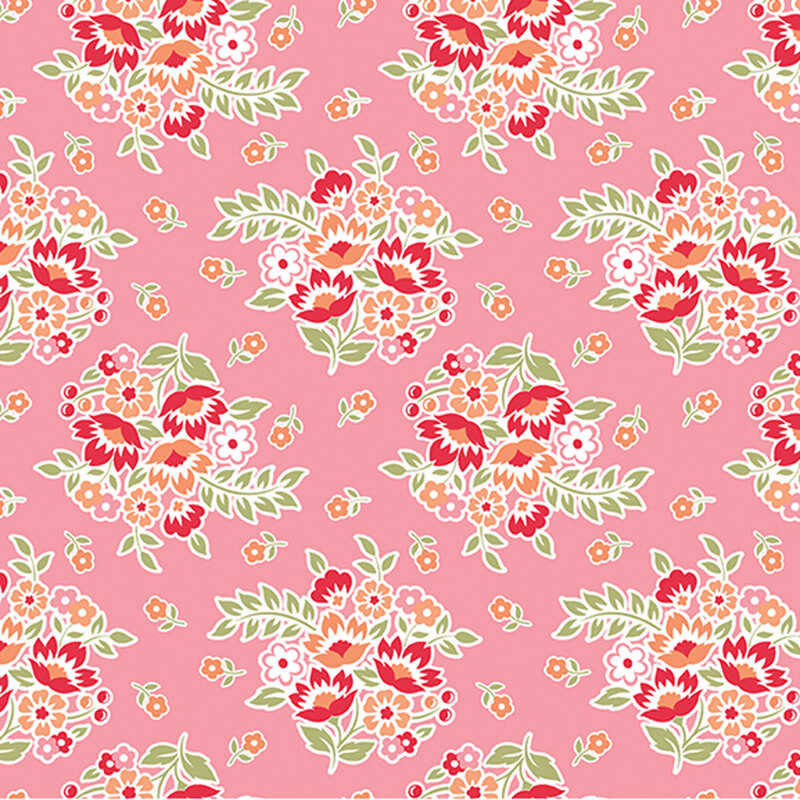 Flower bouquets in red, peach, and pink flowers tossed on pink fabric.