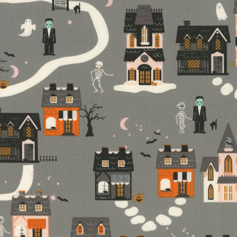 This gray fabric features a whimsical Halloween village with spooky houses, ghosts, bats, pumpkins, and classic monster characters.