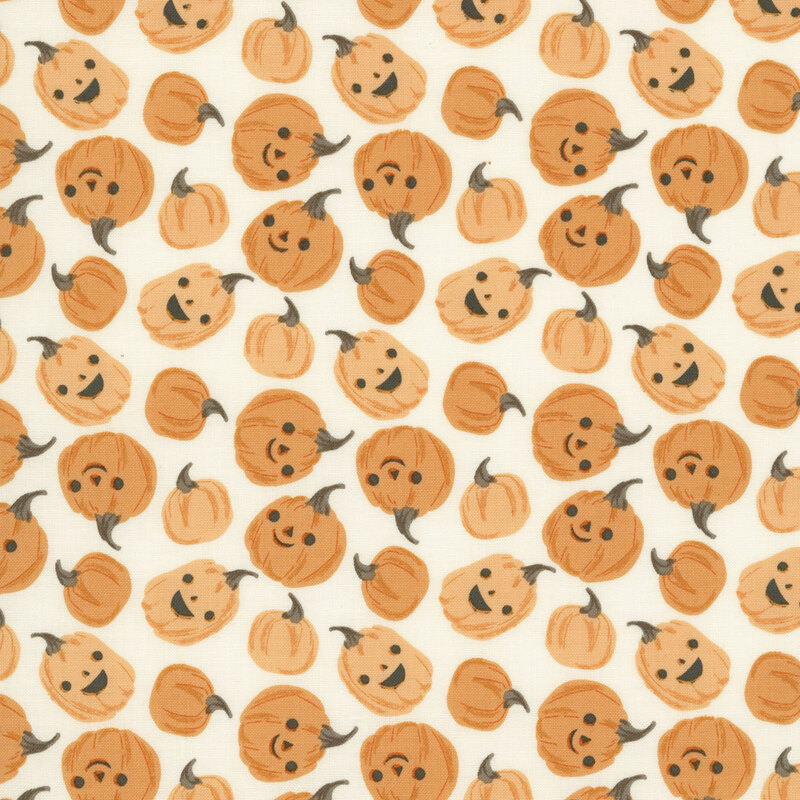 This white fabric features scattered playful pumpkins with smiling jack-o’-lantern faces.