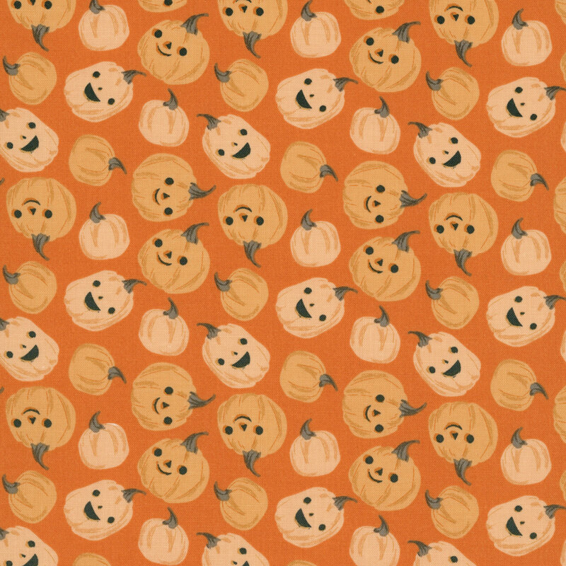 This orange fabric features scattered playful pumpkins with smiling jack-o’-lantern faces.