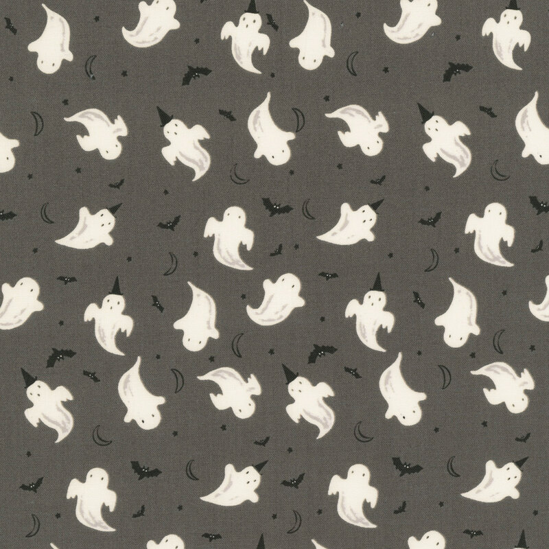 This dark gray fabric features playful glow in the dark ghosts, fluttering bats, crescent moons, and tiny stars.