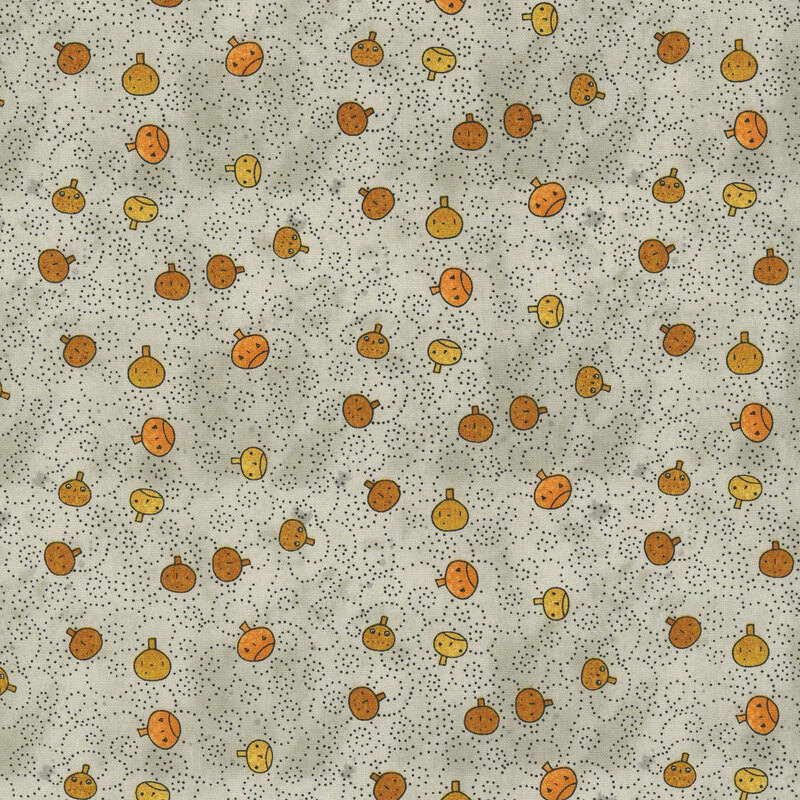 mottled light gray fabric featuring orange pumpkin faces tossed with black dotted swirls.