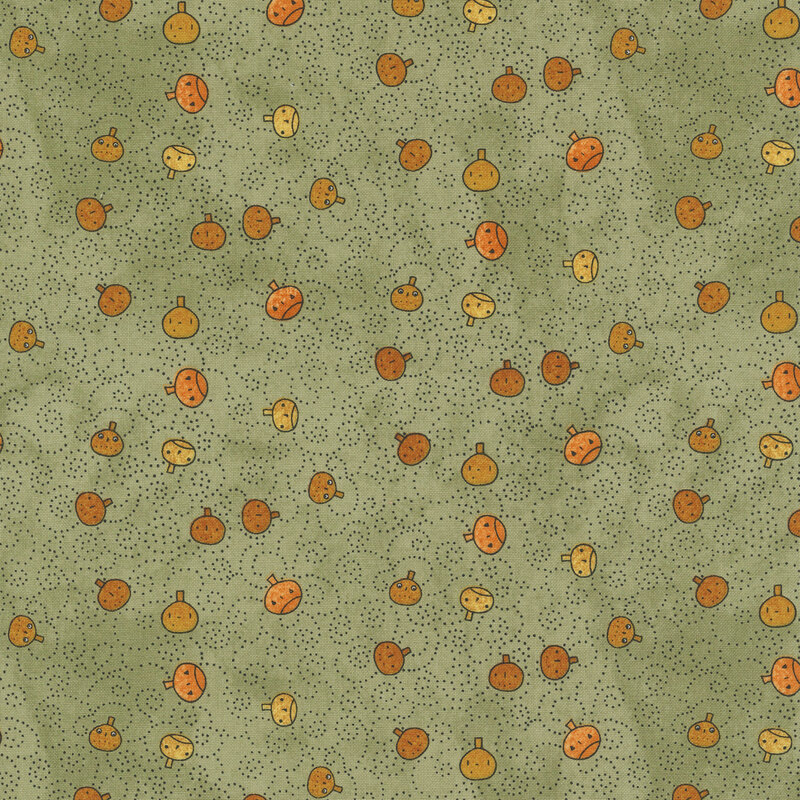 mottled sage green fabric featuring orange pumpkin faces tossed with black dotted swirls.