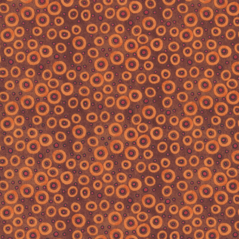 mottled rustic red fabric scattered with orange dots with black outlines and circles in various sizes.