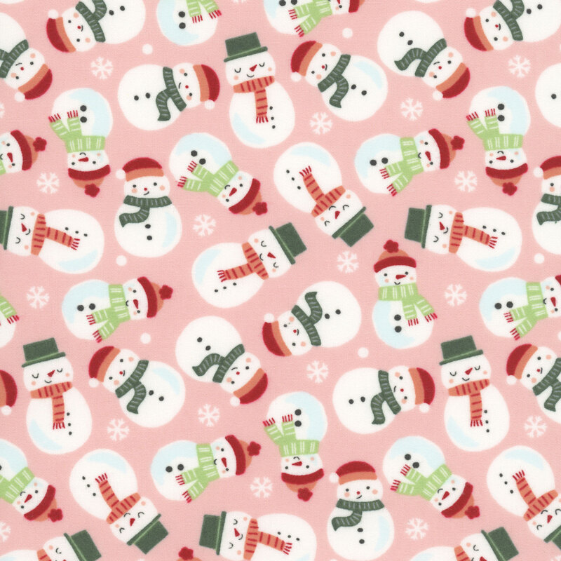A blush pink fabric with tossed snowmen wearing scarves and hats. 