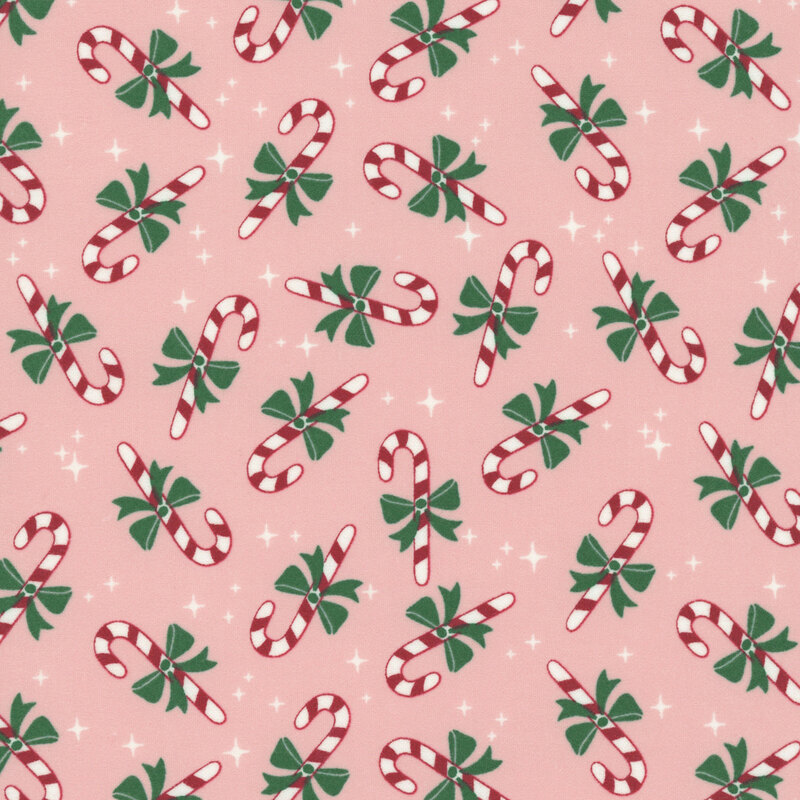 A blush pink fabric with tossed candy canes and white sparkles.  