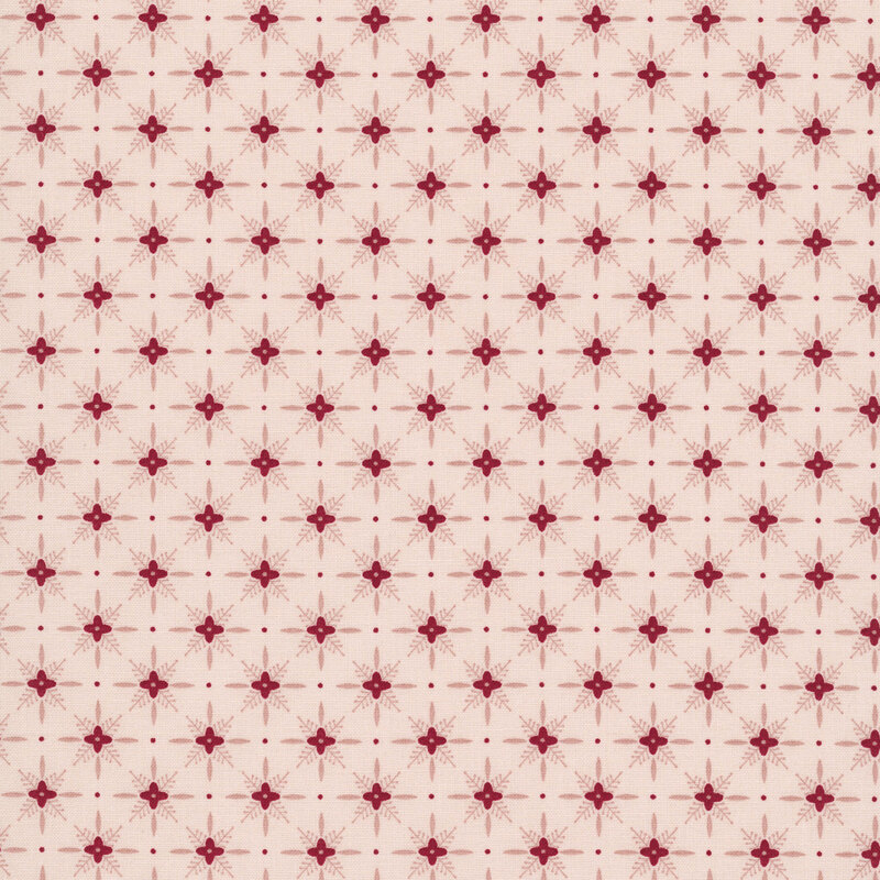 Pink fabric with a red pattern of geometric shapes in a lattice with florals. 