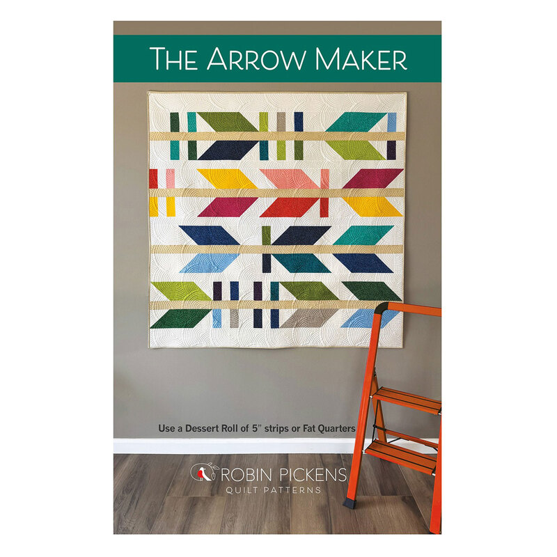 Front cover of the pattern showing completed quilt hanging on a wall of The Arrow Maker quilt.