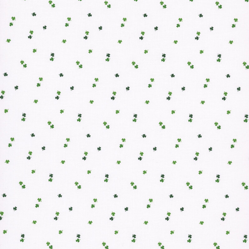 dark and light green shamrocks tossed on a white fabric