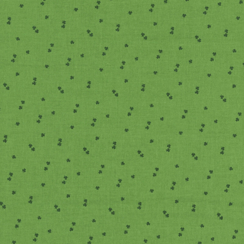 dark green shamrocks tossed on a grass green fabric
